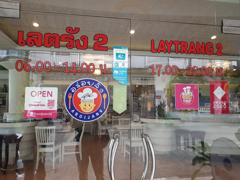 หน้าร้านกระจกพร้อมป้ายชื่อเลตรัง 2 ตัวอักษรสีแดง